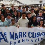 Group photo of students, mentors, and volunteers at AI Bootcamp holding banner