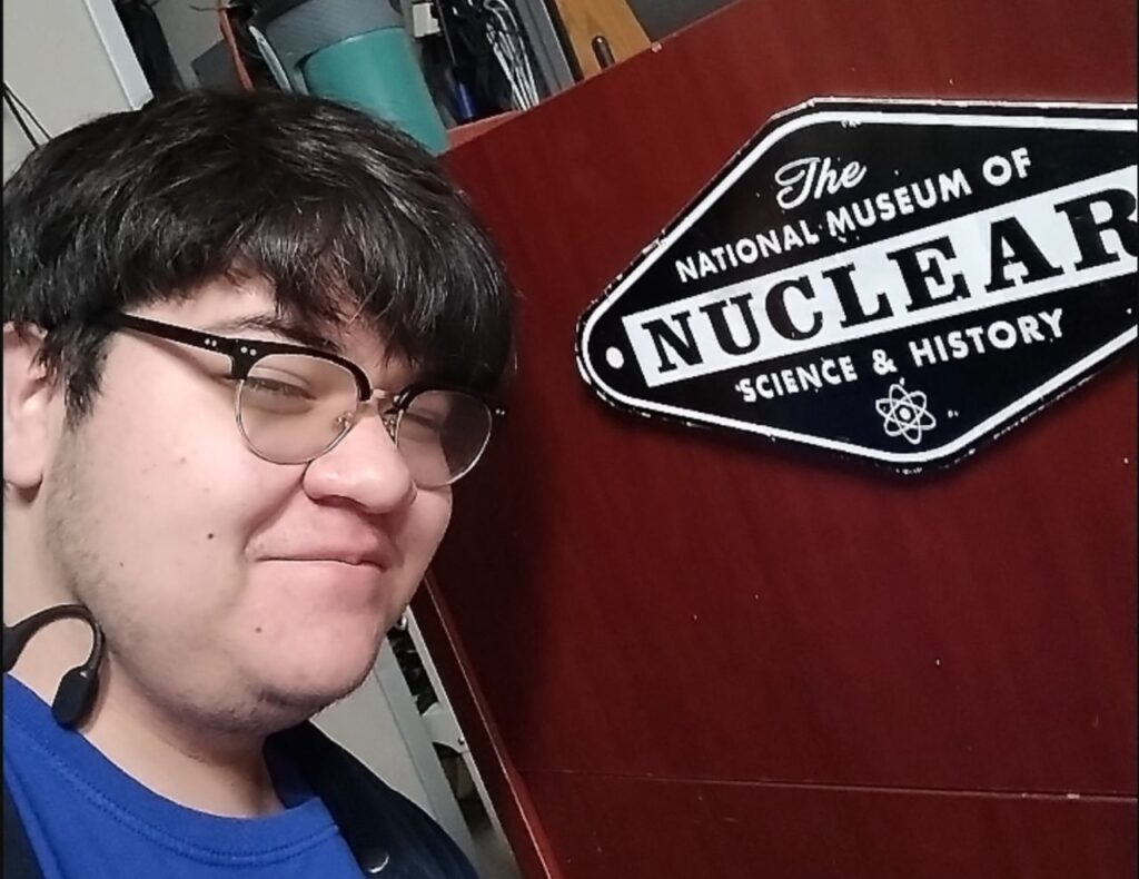 Student posing in front of The National Museum of Nuclear Science and History sign