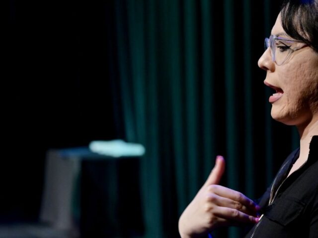 Dylan M. Rafaty speaking while interpreter signing American Sign Language